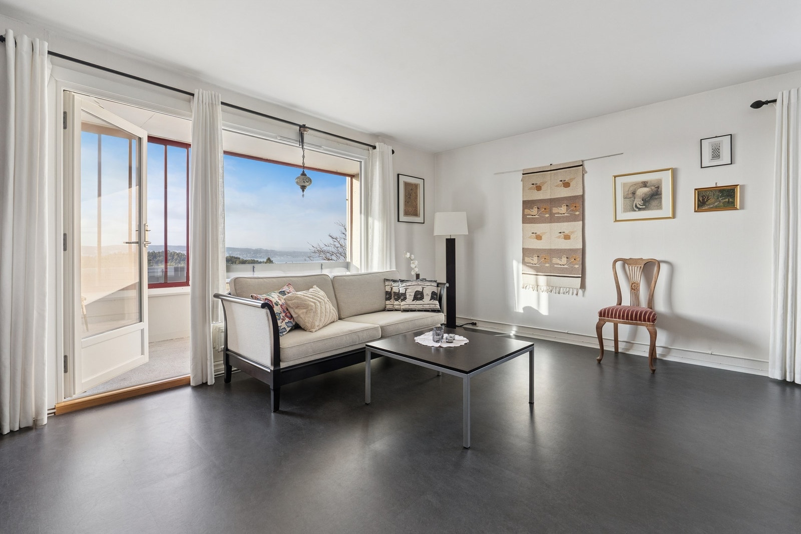 Store vindusflater og direkte utgang til balkongen gir stuen en åpen og luftig atmosfære. Galleribilde