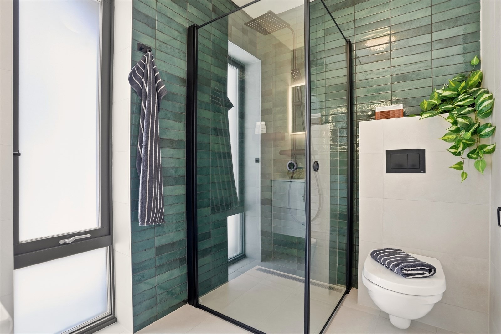 Badet i 1.etasje har vegghengt toalett og dusjvegger/hjørne med nedsenket gulv. Gulvet er flislagt og har gulvvarme. Galleribilde