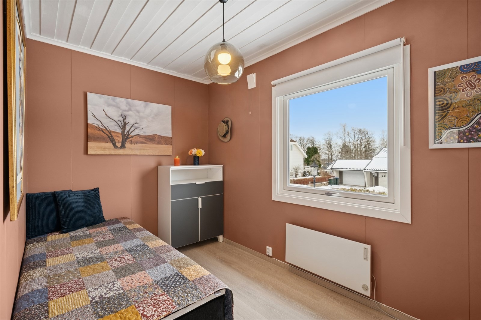 Lyst og trivelig soverom med varme fargetoner, stort vindu og plass til både seng og oppbevaring Galleribilde