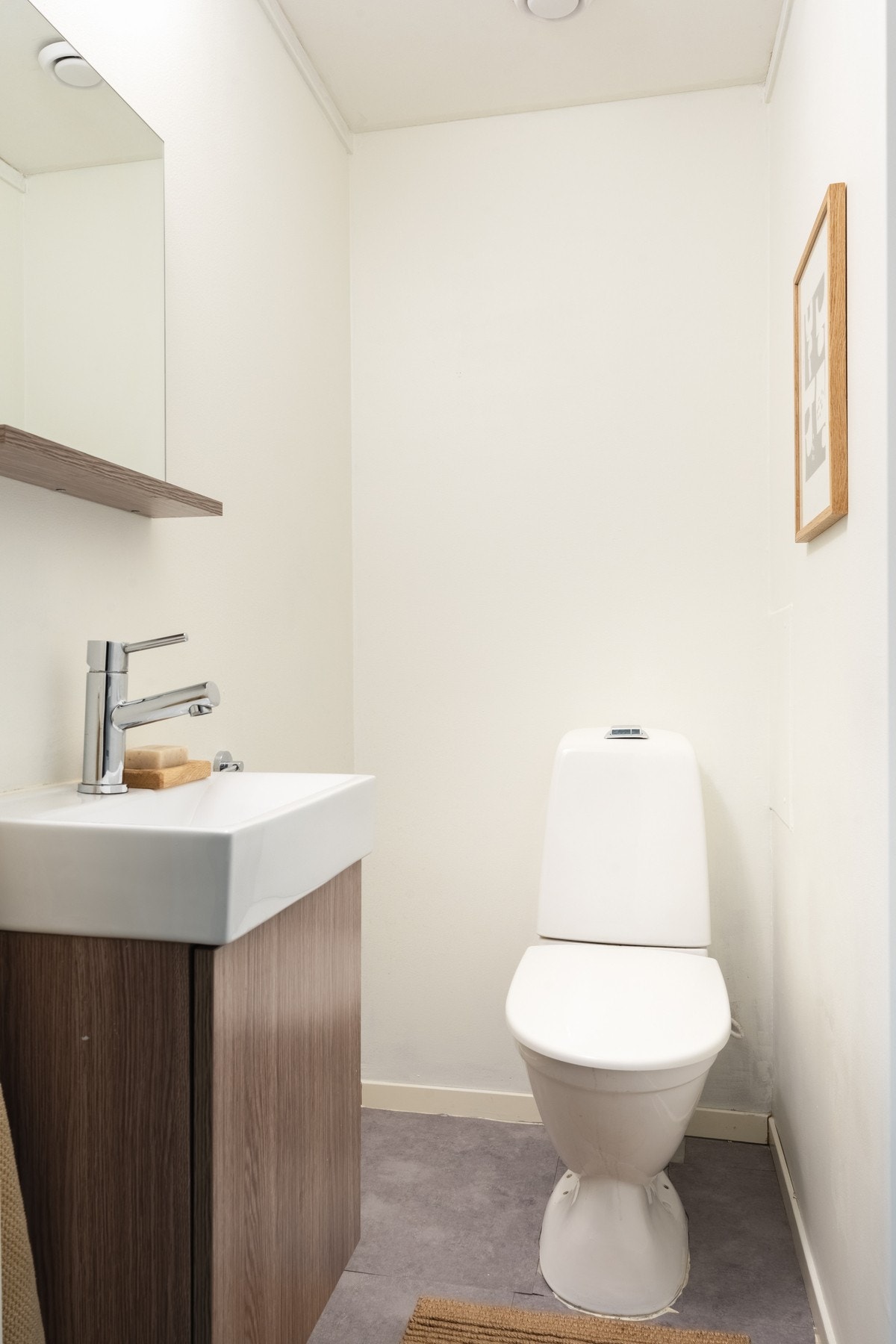 Toalettrommet måles til 1,4 kvm. og har også vinyl på gulv, og slette malte vegger. Det er innredet med toalett og baderomsmøblement med servant og speil. Galleribilde