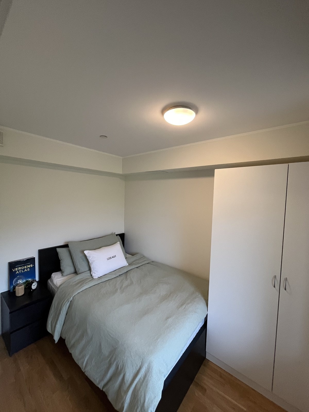 Rolig og harmonisk soverom med parkettgulv og lyse, nøytrale overflater Galleribilde