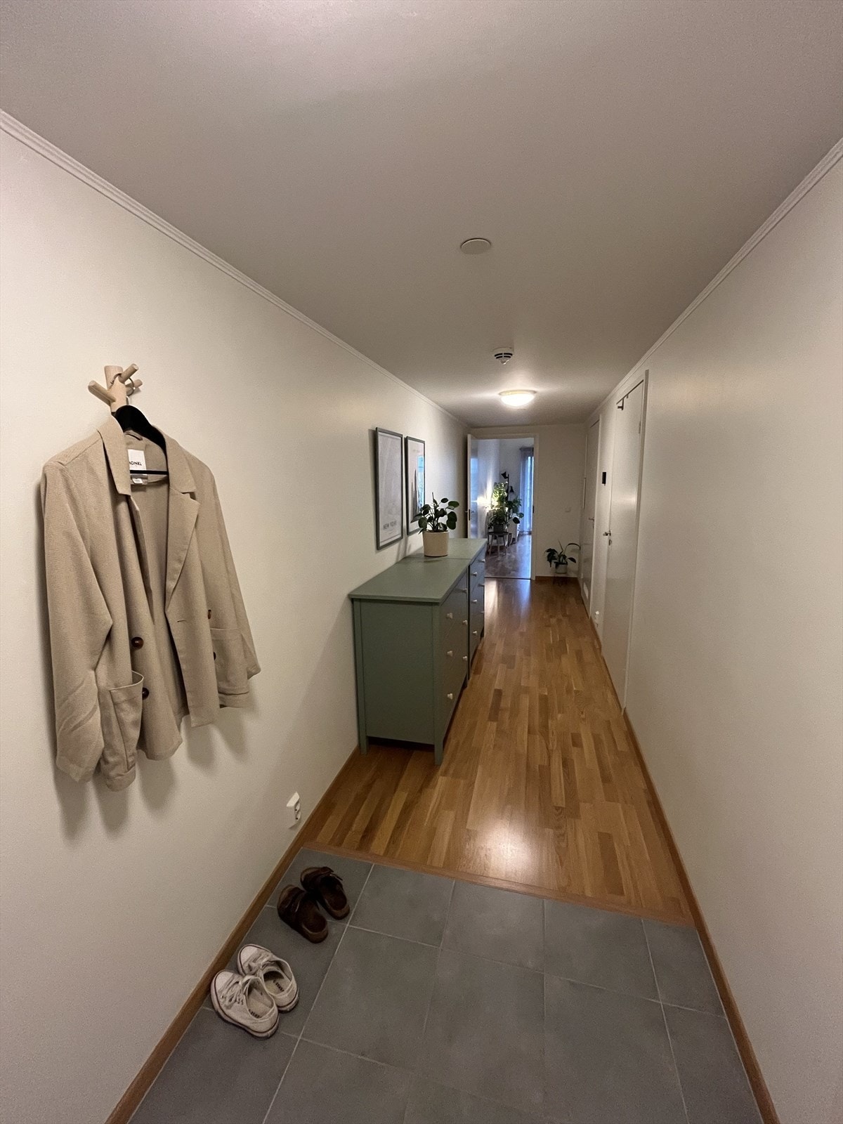 Innbydende og lys entré med parkettgulv og delikate, malte flater i lyse toner. Galleribilde