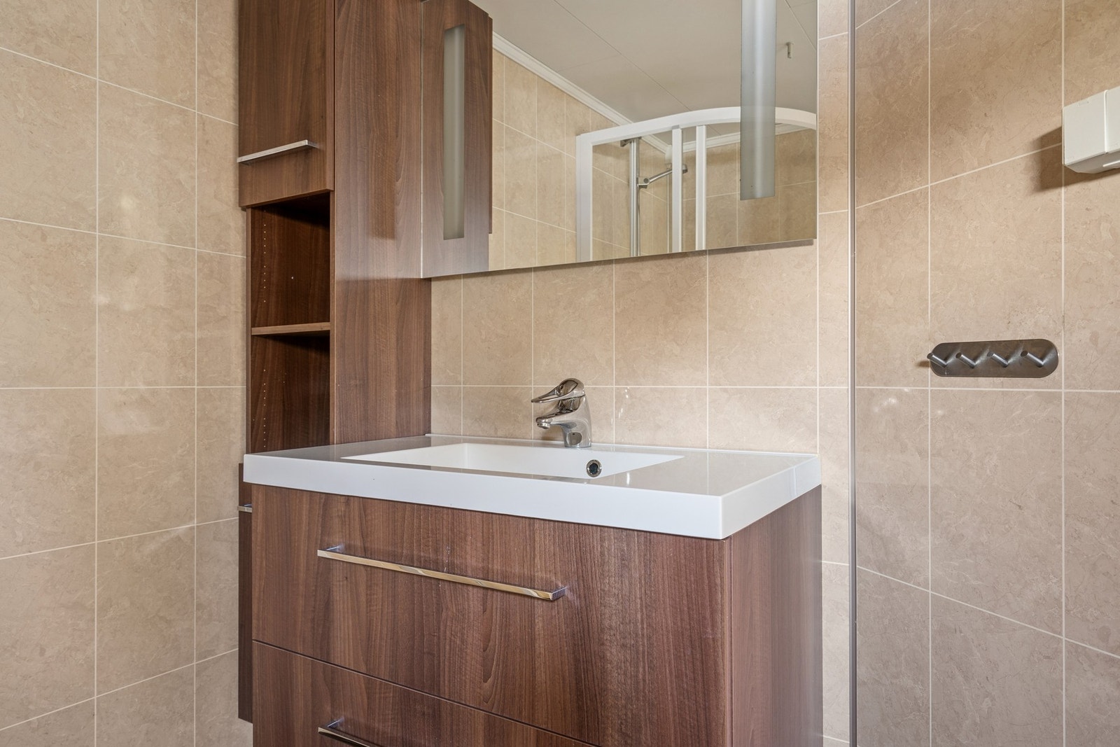 Utstyrt med dusjhjørne, veggmontert toalett, servantskap og servant. Galleribilde