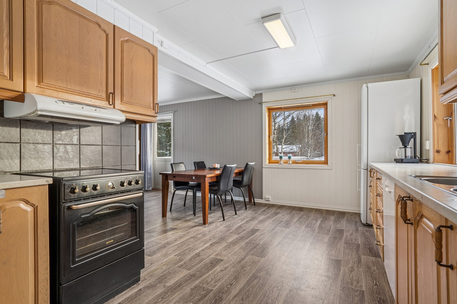 Laminat på gulv, malt overflate ved flis over benkeplate på vegger og malt overflate i himling. Galleribilde