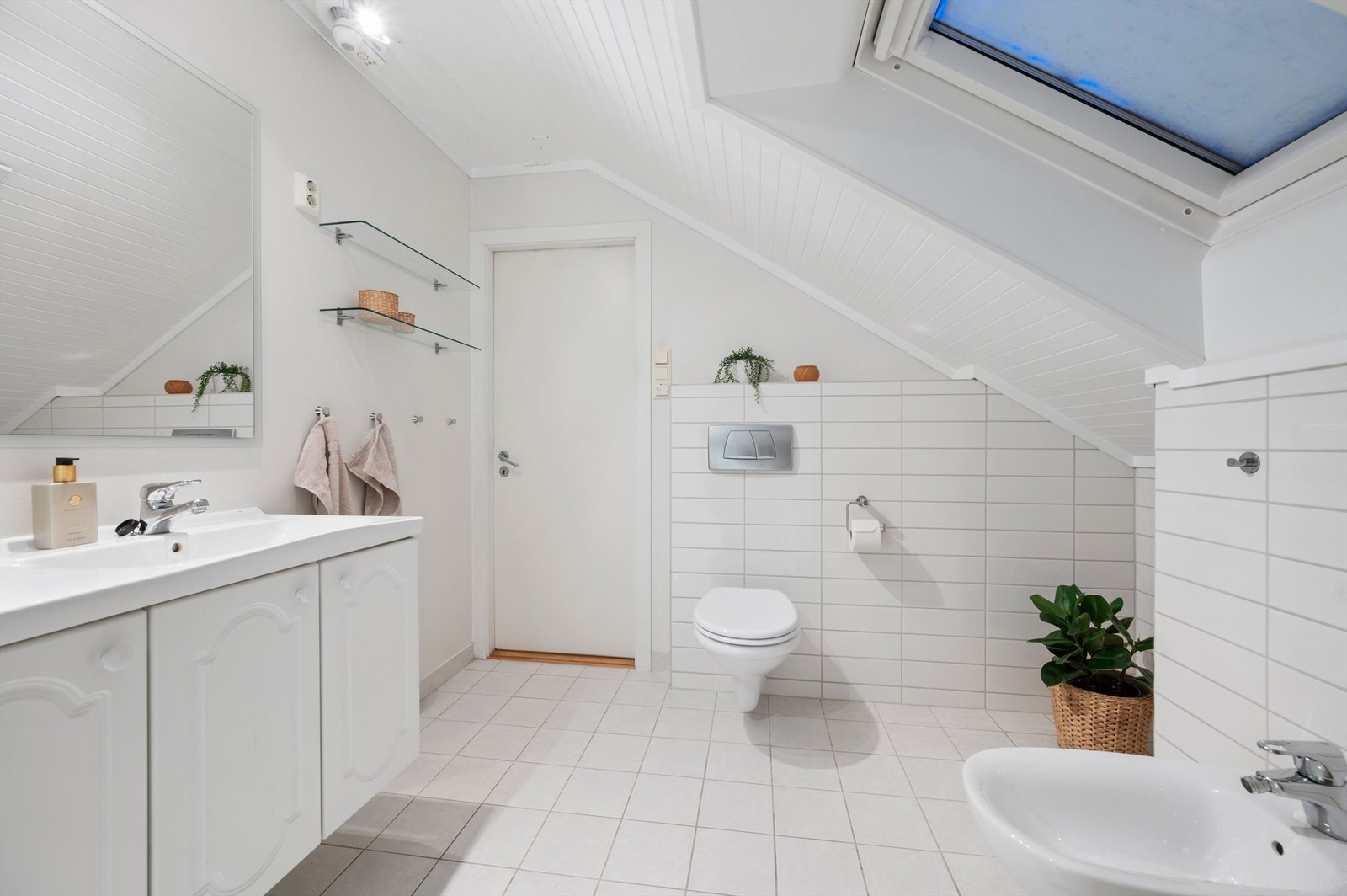 Badet er videre utstyrt med servantskap med speil, dusjhjørne, bidé og vegghengt toalett. Galleribilde