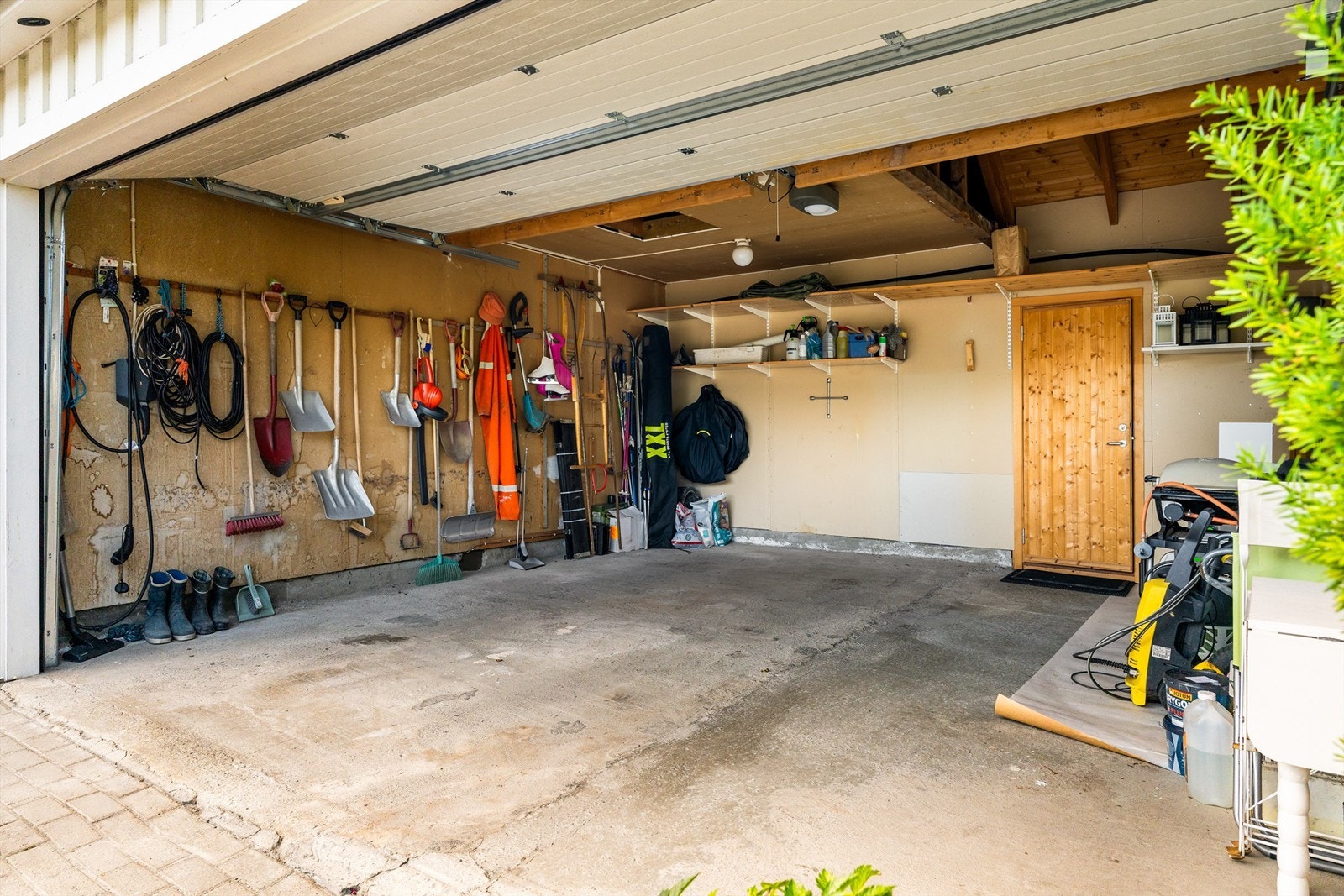 Det er etablert en dobbeltgarasje med elbillader i tillegg til flere biloppstillingsplasser på tomten. Boden i bakkant måler romslige 9 kvm og har gode oppbevaringsmuligheter. Galleribilde