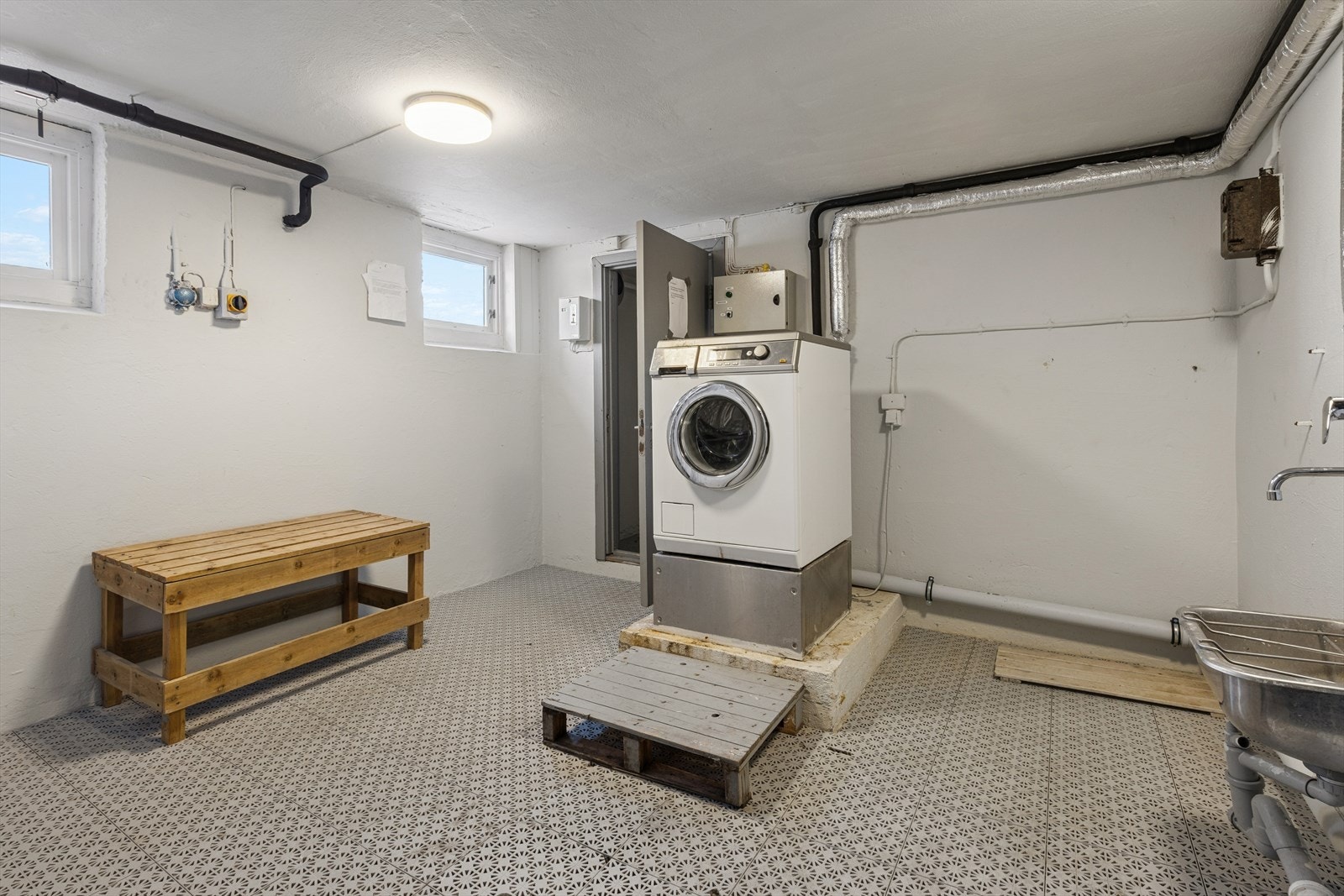 Det er et fellesvaskeri og tørkerom i kjeller som beboere kan benytte seg av. Galleribilde