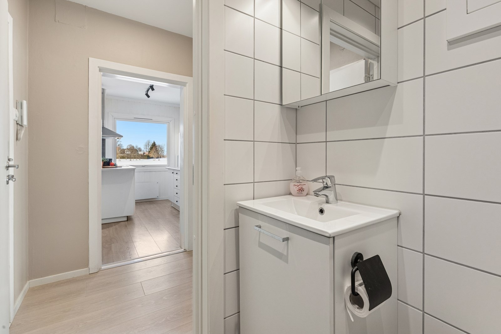 Flislagt bad/wc med varmekabler i gulv, servantskap, speil, vegghengt toalett og svingbare dusjdører. Galleribilde