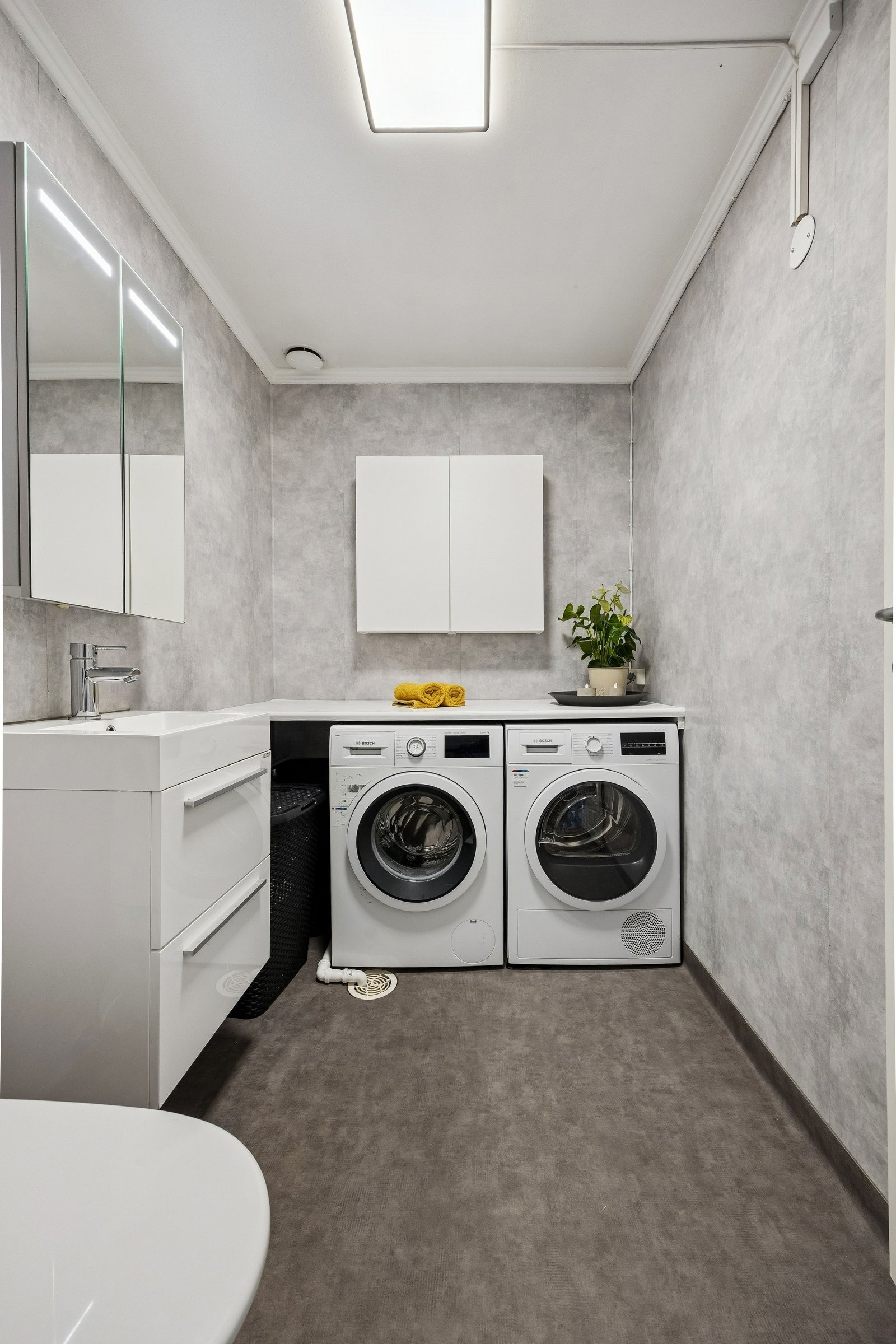 Vaskerom med enkel servant og toalett.
Vaskerommet har varme i gulv. Galleribilde