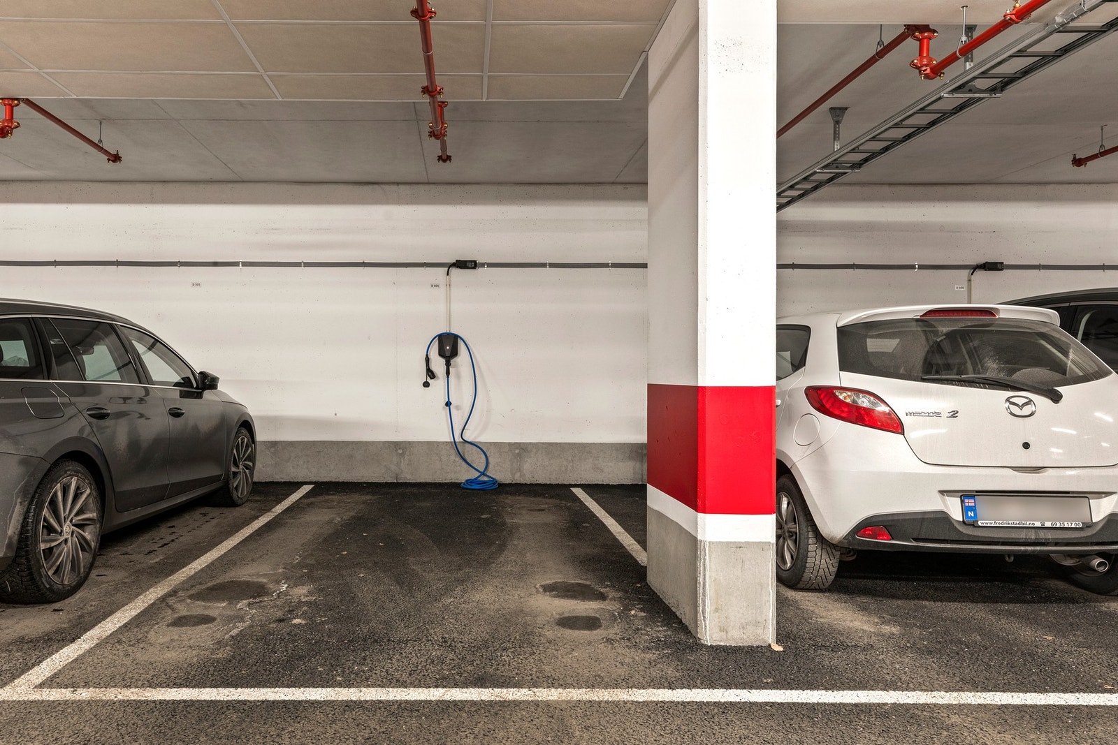 Parkeringsplass i kjeller med elbillader. Galleribilde