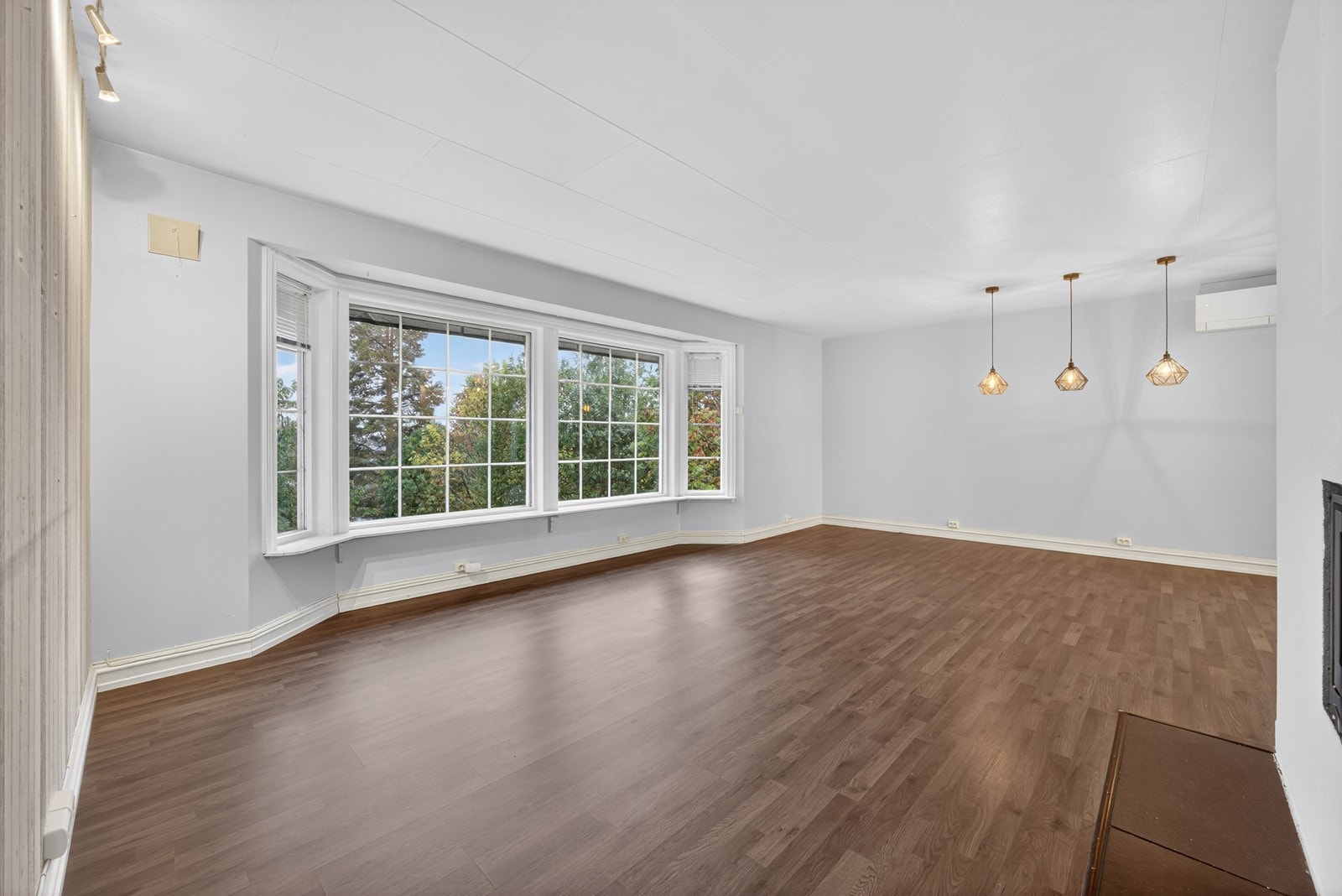 Stor og tiltalende stue med laminat på gulv og malte slette overflater. Galleribilde