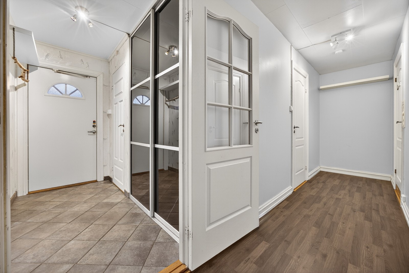 Innbydende entrè som gir et godt førsteinntrykk av boligen. Rommet har fliser på gulv og tapetserte veggflater. Stor skyvedørsgarderobe som sørger for rikelig med oppbevaringsplass. Galleribilde