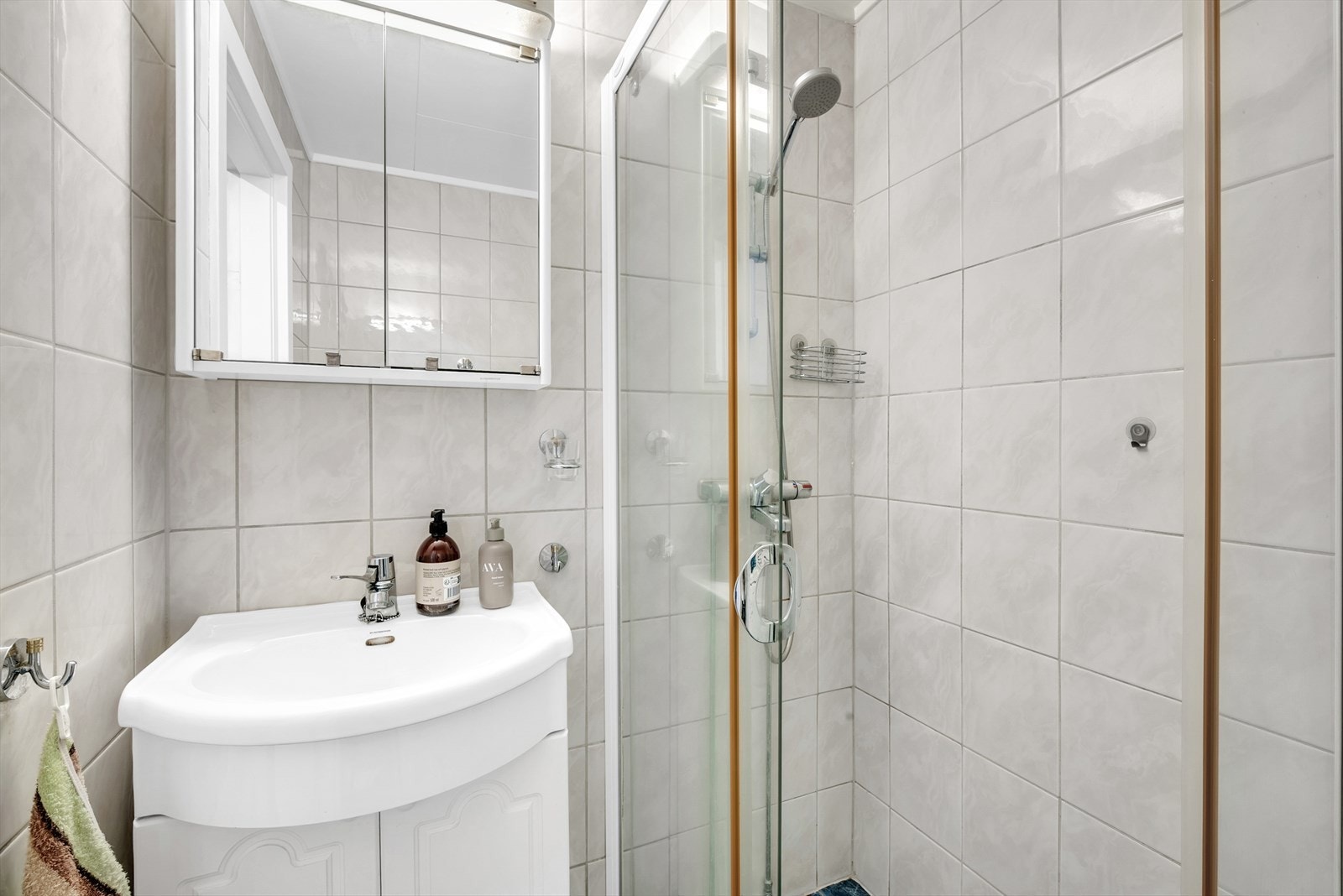 Badet er innredet med dusjhjørne, servant med underskap og speilskap med overlys. Galleribilde