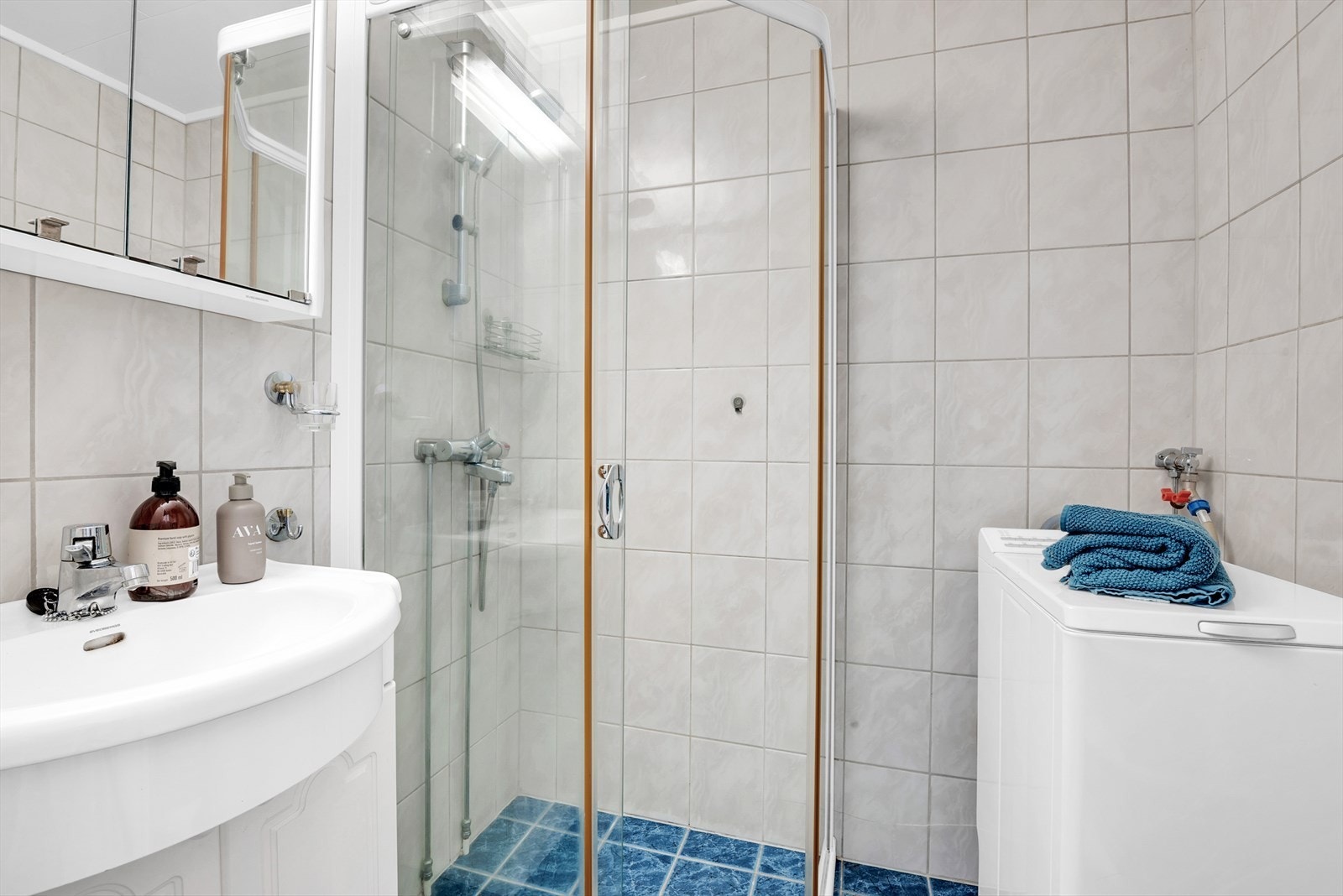 Flislagt bad med elektriske varmekabler i gulvet og opplegg for vaskemaskin. Galleribilde