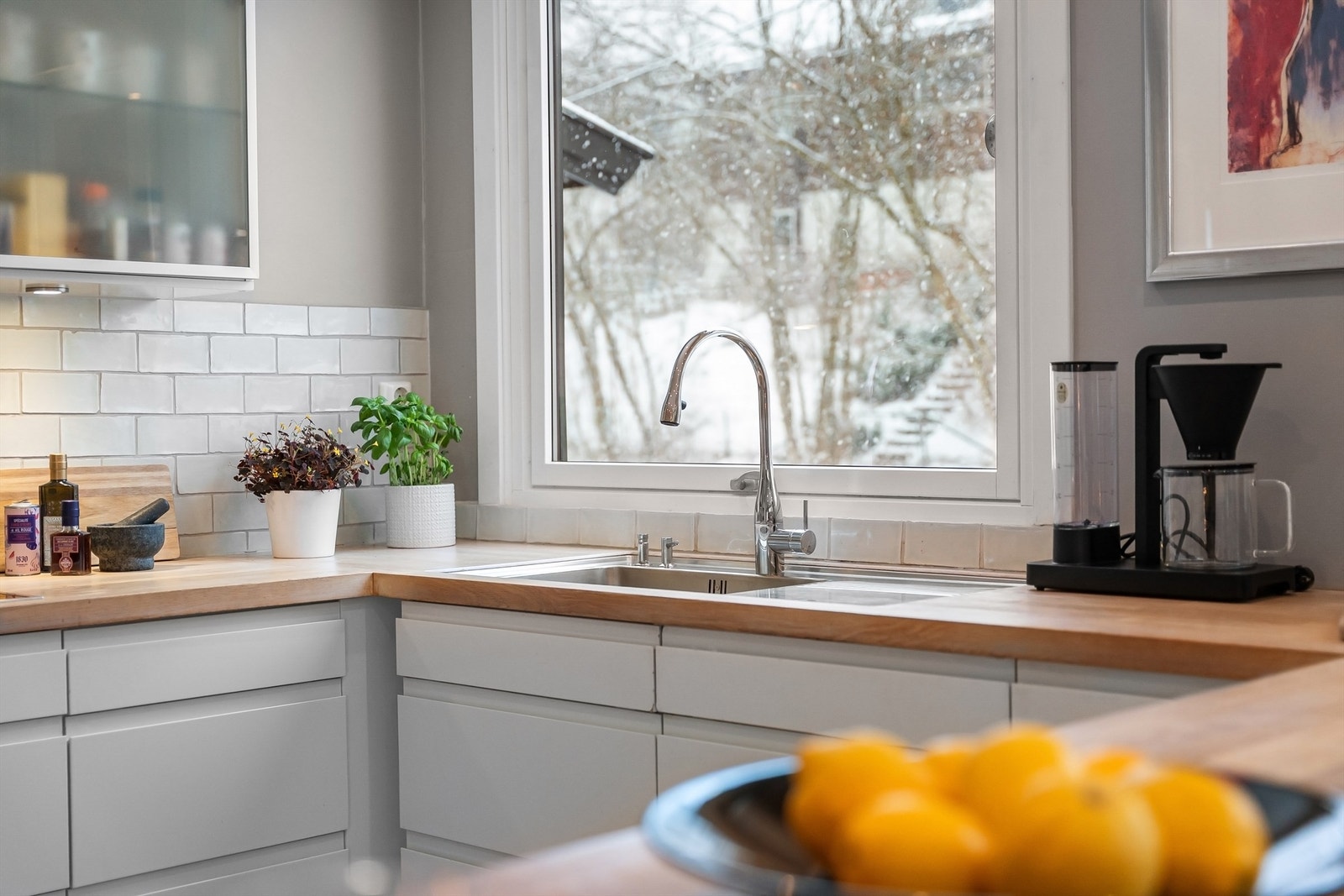 Nedsenket oppvaskkum med ett-greps armatur og fliser mellom benk og overskap. Galleribilde