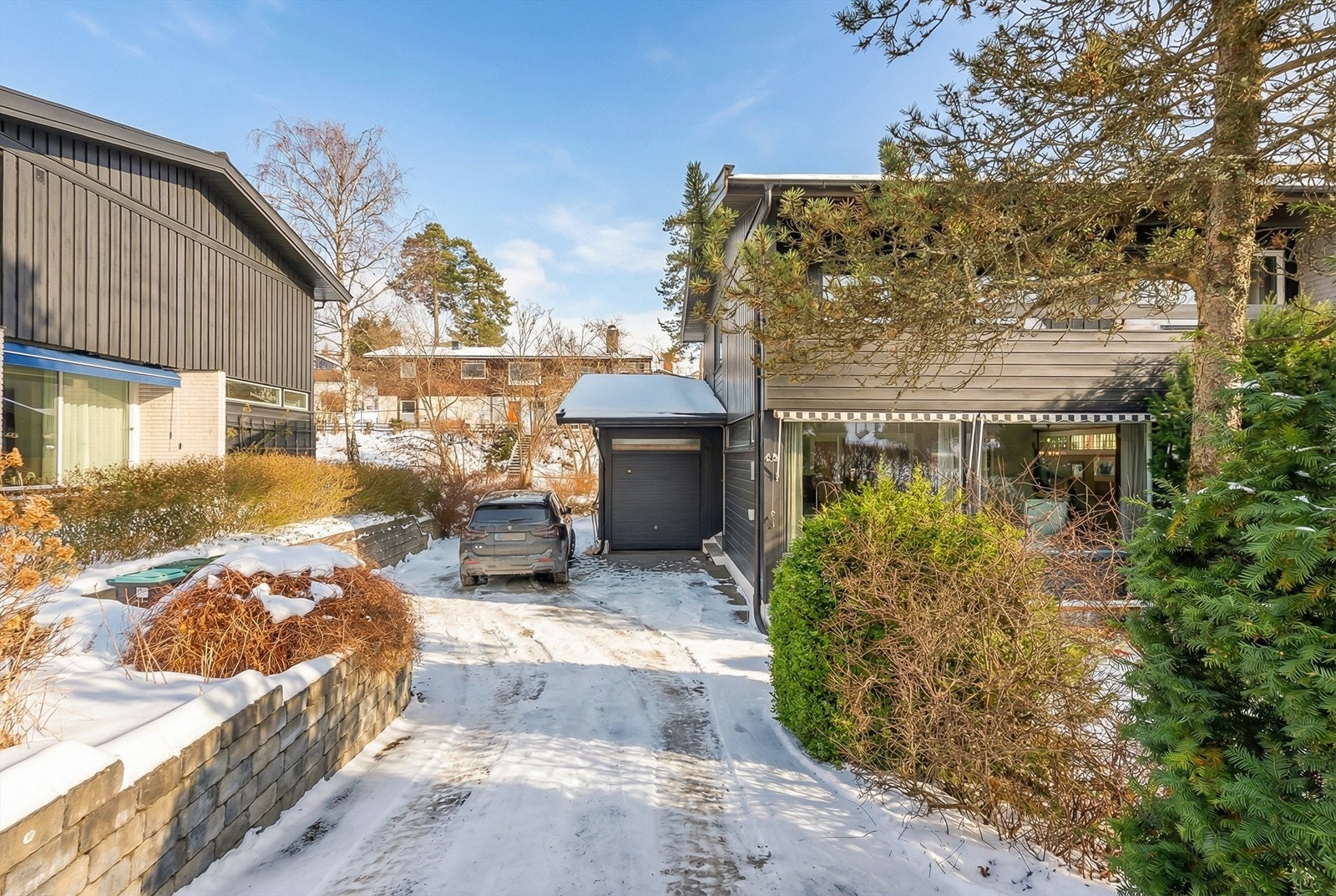 Garasje på siden av bygget, samt el-bil lader montert utvendig. Galleribilde