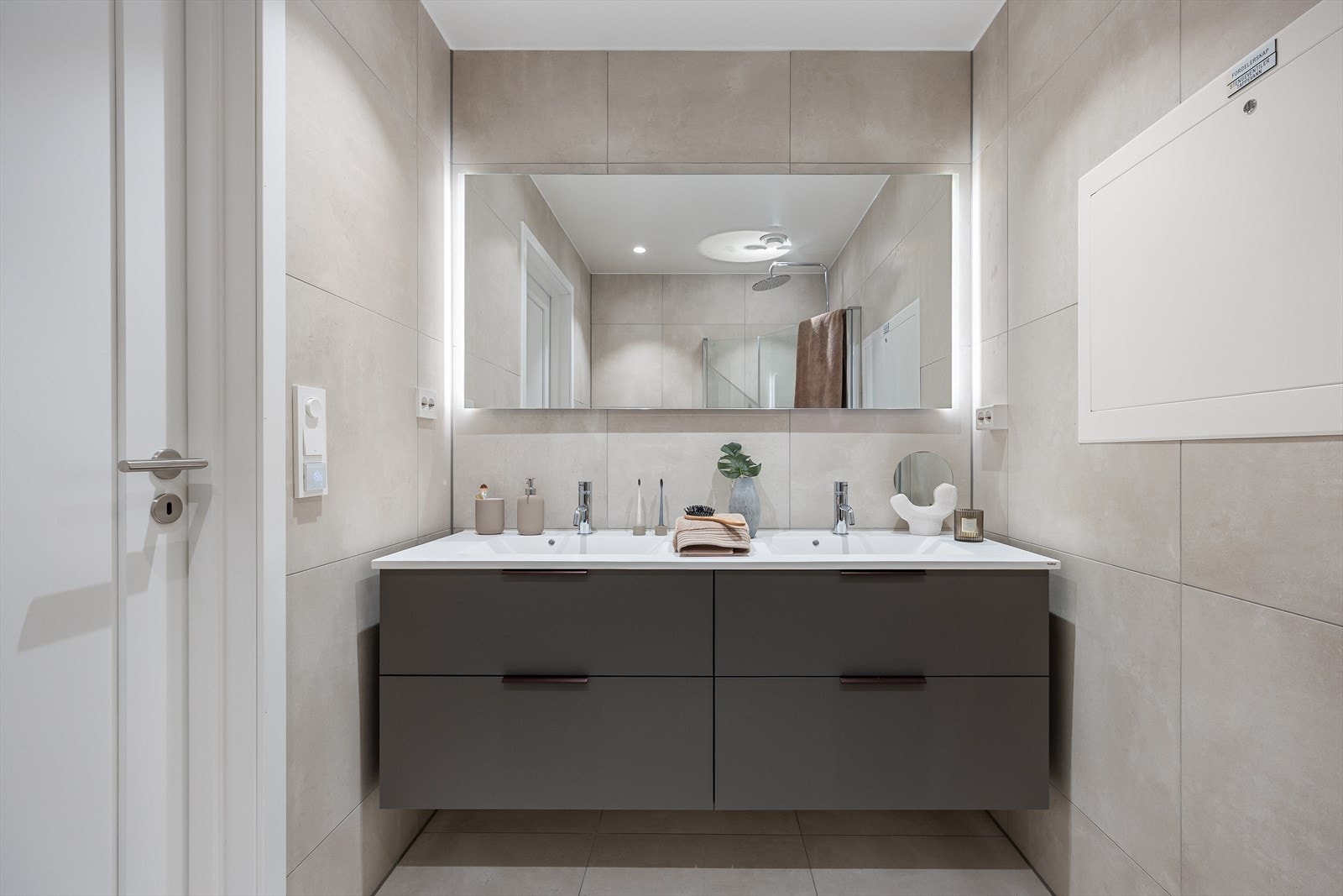 Badet tilknyttet hovedsoverommet har delikate fliser på gulv og vegger som badet fra gangen. Begge badene er plassbygde. Galleribilde