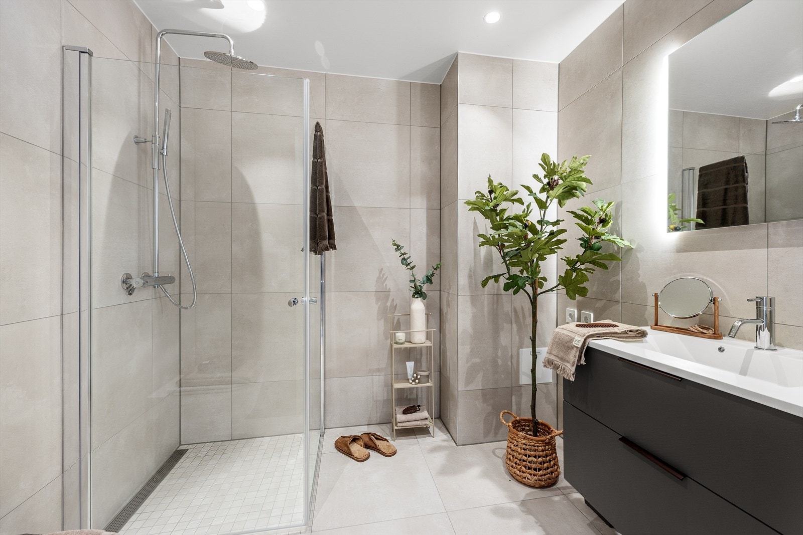 Badet med adkomst fra gangen har enkel servantinnredning, veggmontert toalett, dusjhjørne med regnfallsdusj og opplegg for vaskmaskin/tørketrommel. Galleribilde