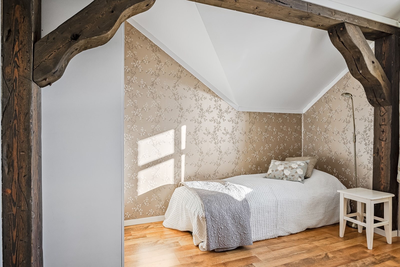 Soverommet har laminat på gulv, malte overflater kombinert med en nydelig tapet og synlige takbjelker som gir en lun og god atmosfære. Galleribilde