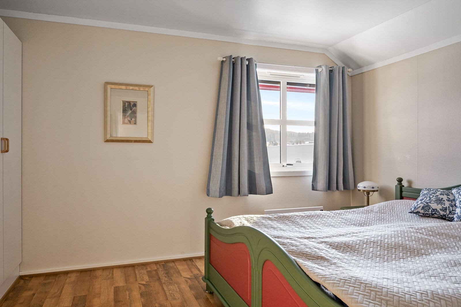 Soverommet har laminat på gulv og overflater malt i en lys varm farge. Galleribilde