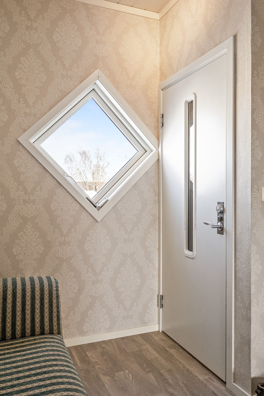 Entréen har laminat på gulv, pen tapet på veggene og to vinduer som slipper inn fint lys. Galleribilde