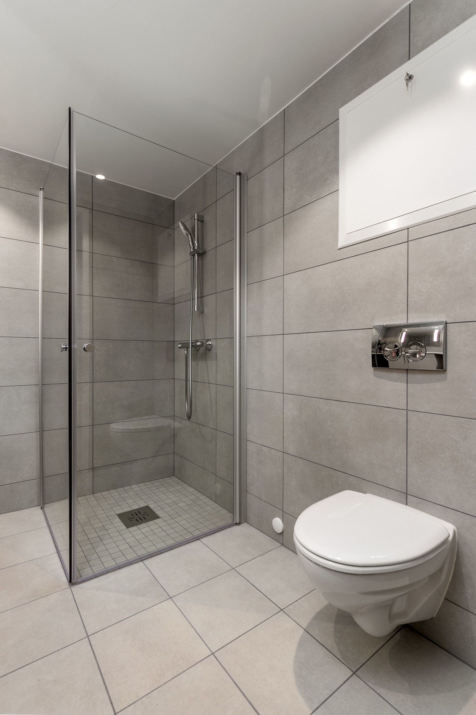 Badet har vegghengt toalett med innbygget sisterne, servant med skapinnredning samt speil med belysning. Galleribilde