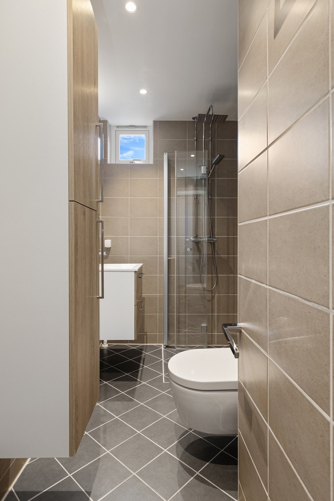 Bad med fliser på golv og vegger. Galleribilde