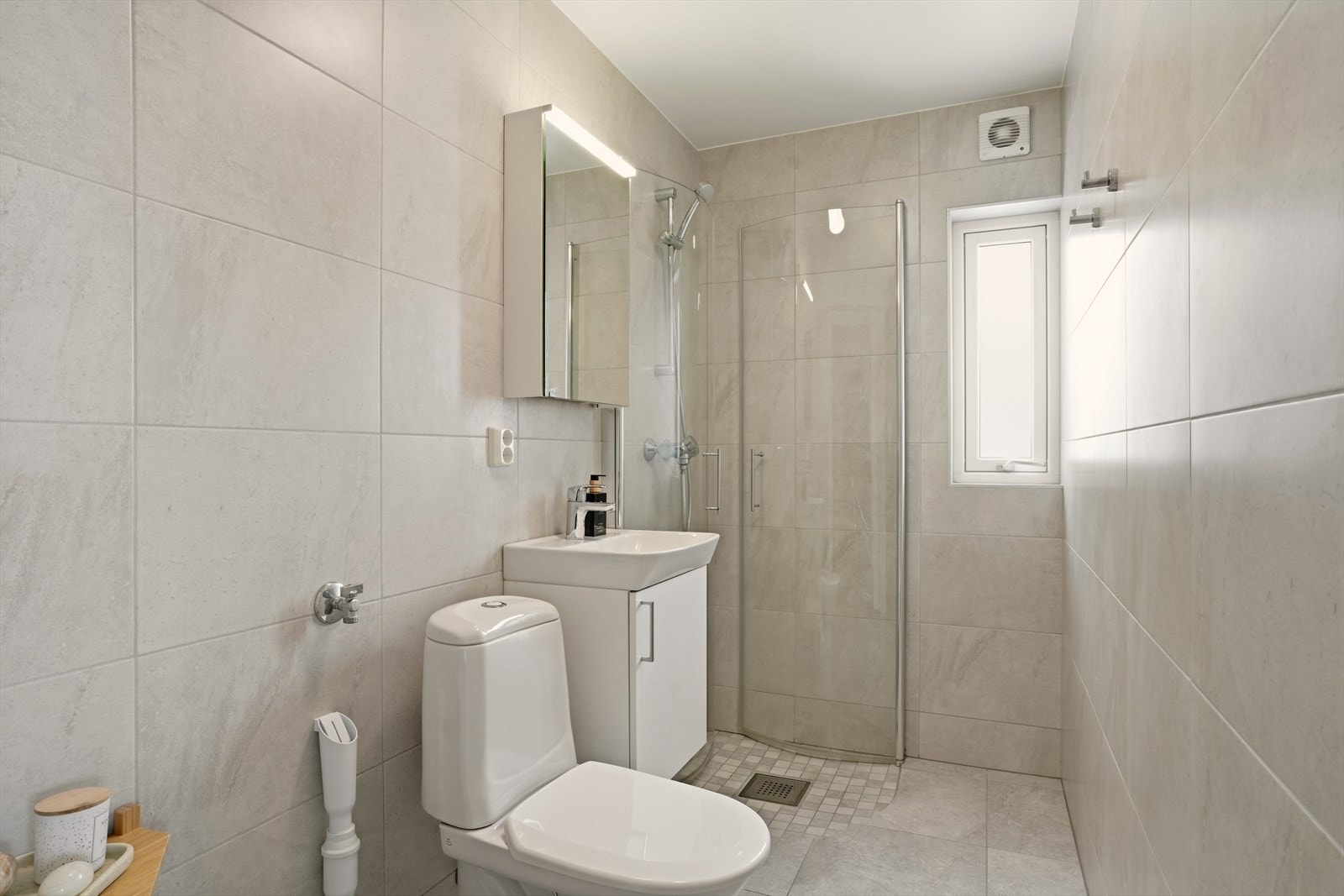 Under servanten er det et praktisk skap til oppbevaring og skap med lys/speil over vasken. Det er også opplegg for vaskemaskin. Galleribilde