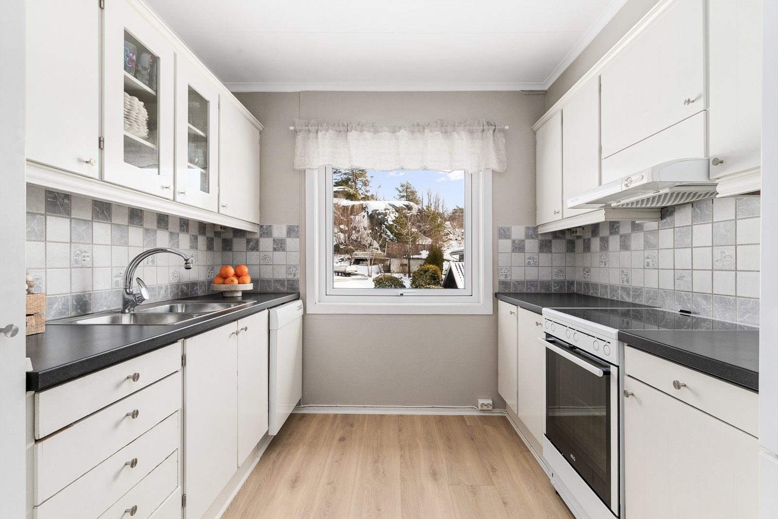 Kjøkkenet er smart utnyttet med gode skap- og benkeplasser på begge sider. Galleribilde