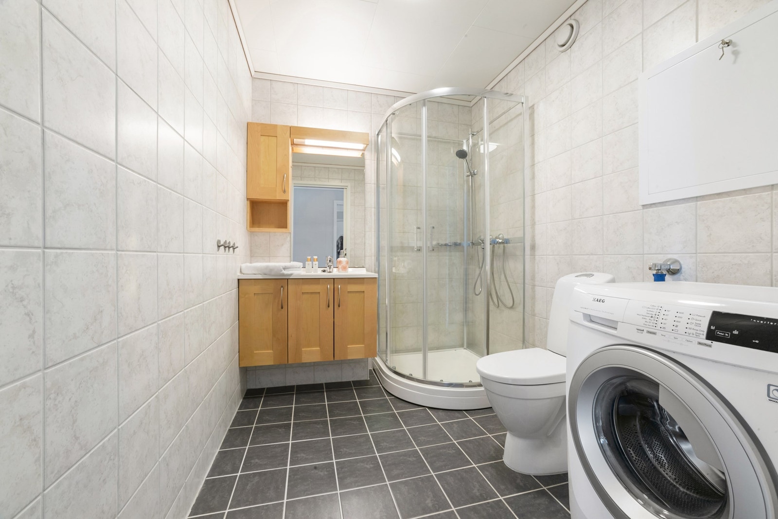 Lyst og romslig bad med fliser og varmekabler Galleribilde