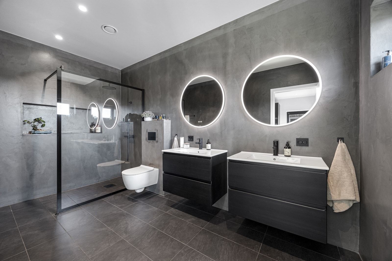 Baderom med stor dusj, integrert hylle, to servanter og vegghengt toalett. Galleribilde