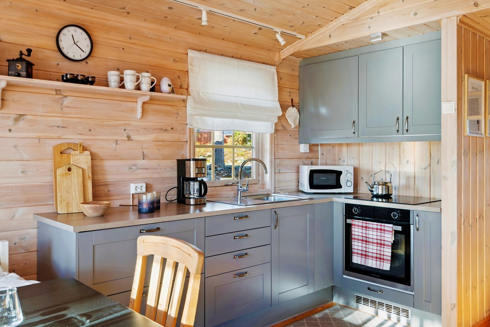 Kjøkkeninnredningen fra 2020 har profilerte fronter, laminatbenkeplate og integrerte hvitevarer. Galleribilde