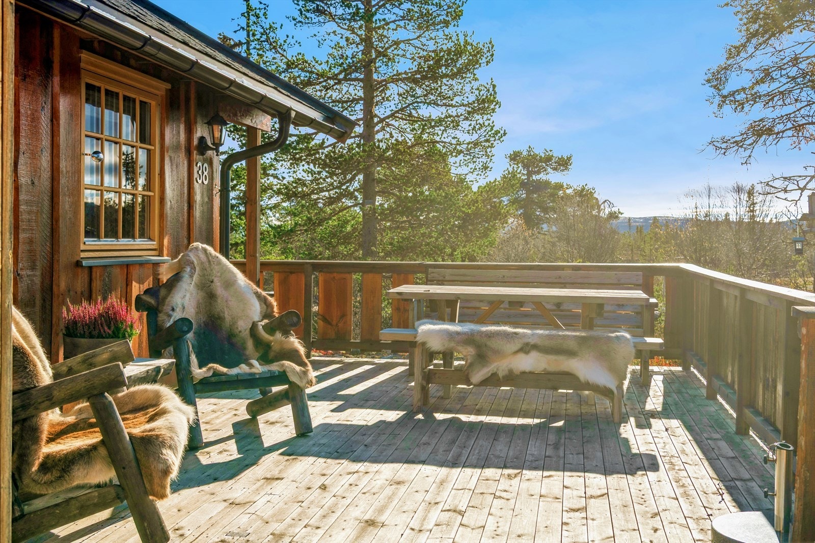 Romslig veranda som strekker seg langs hyttas fasade og gir rikelig med uteplass. Galleribilde
