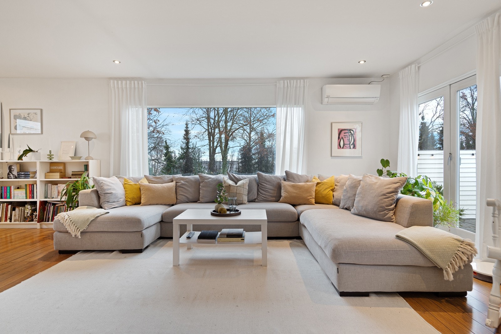 Lys og romslig stue med store vindusflater som gir rikelig naturlig lys og en behagelig atmosfære Galleribilde