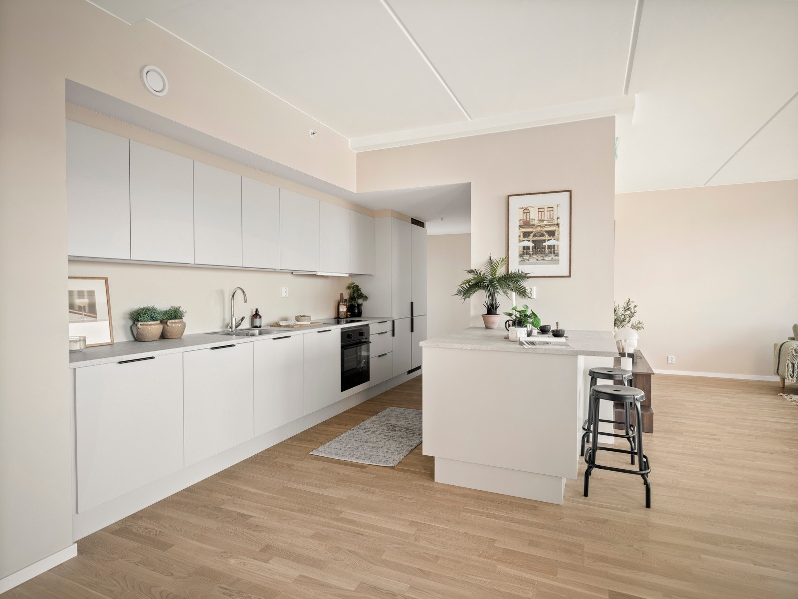 Påkostet kjøkken fra HTH med slette beige fronter, integrerte hvitevarer og flott kjøkkenhalvøy. Galleribilde