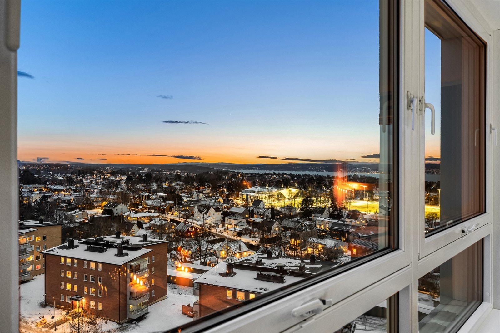 Utsikten strekker seg over hustak mot fjorden fra stuen og soverom. Galleribilde