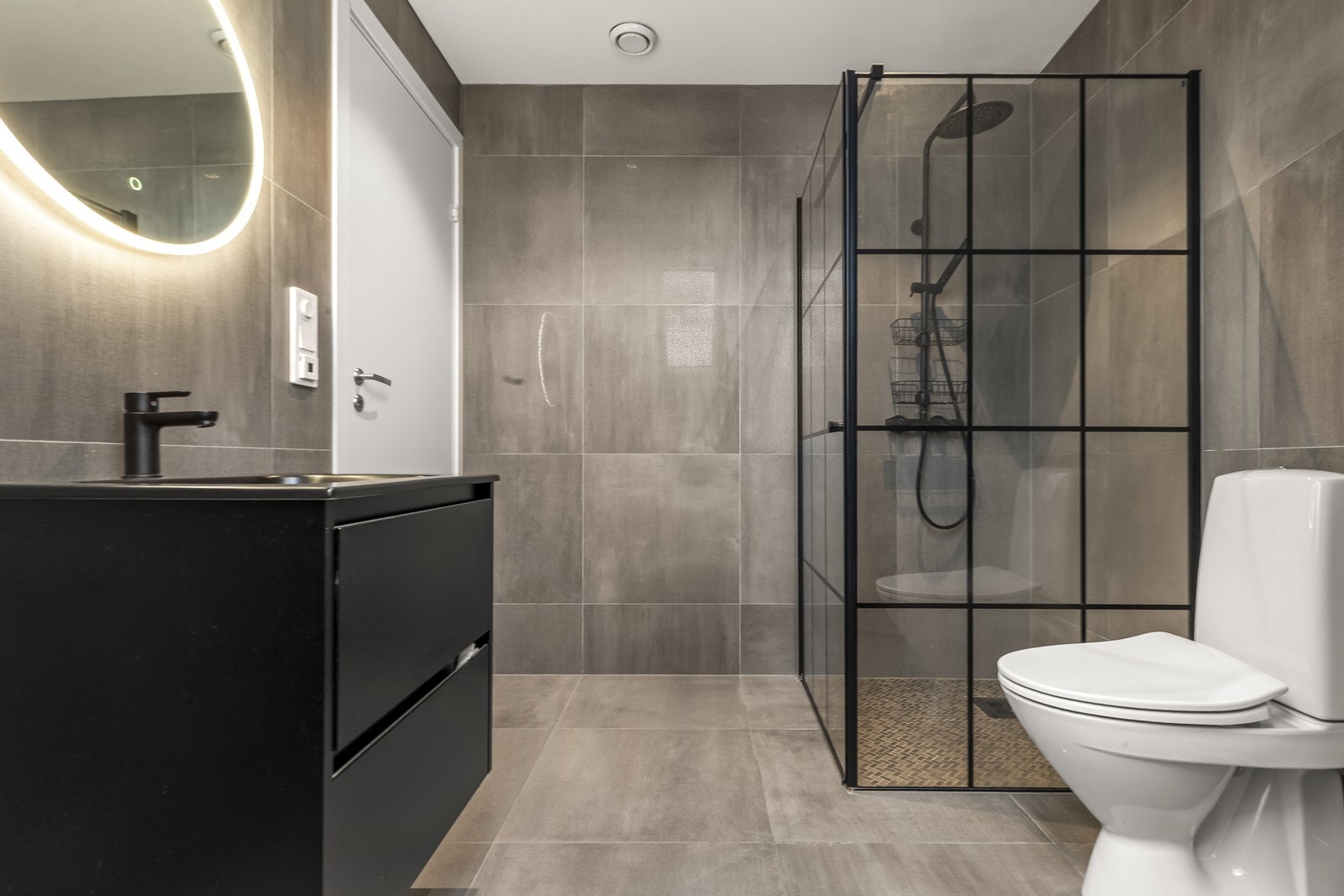 Badet i andre etasje er moderne med flislagte overflater og downlights i taket. Galleribilde