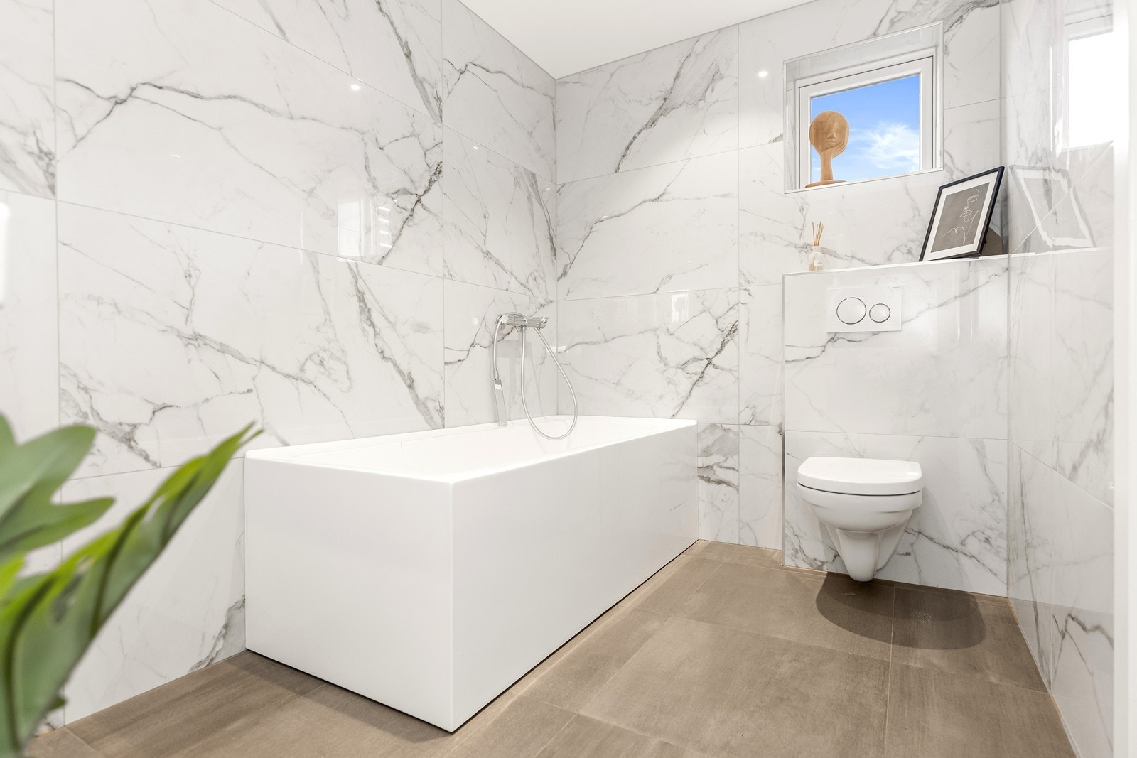 Badet i første etasje er elegant flislagt og utstyrt med badekar. Galleribilde