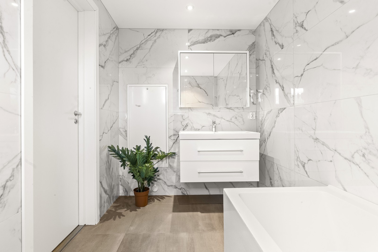 Rommet har en stilren innredning, veggmontert toalett og elektriske varmekabler i gulvet. Galleribilde