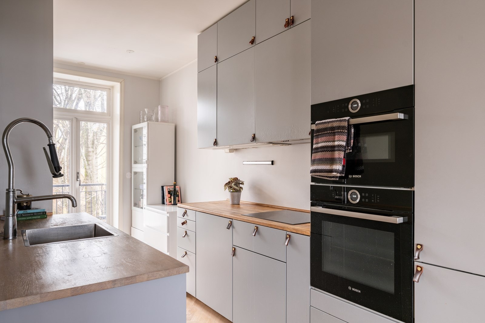 Åpen kjøkkenløsning med heltre benkeplate og integrerte hvitevarer Galleribilde