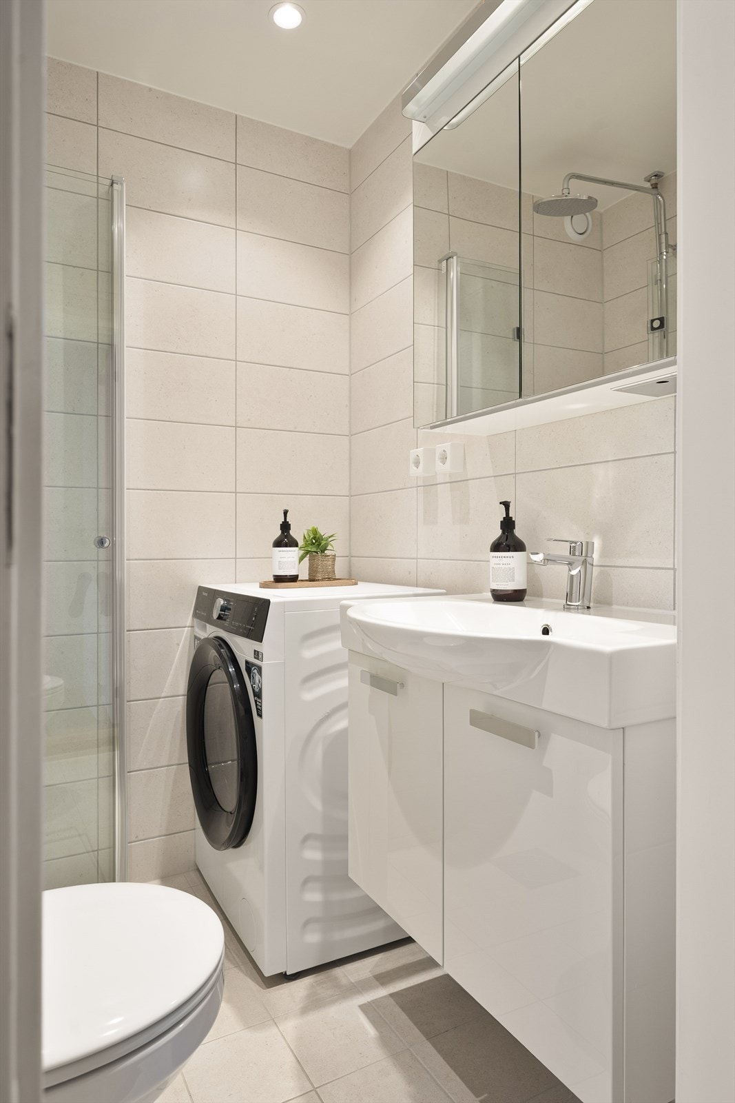 Innredningen består av servant, speilskap med belysning, dusjsone, gulvstående toalett og opplegg for vaskemaskin. Galleribilde