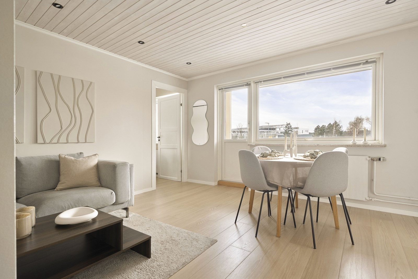 Gjennomgående laminatgulv og malte panelplater i taket skaper en helhetlig stil. Galleribilde