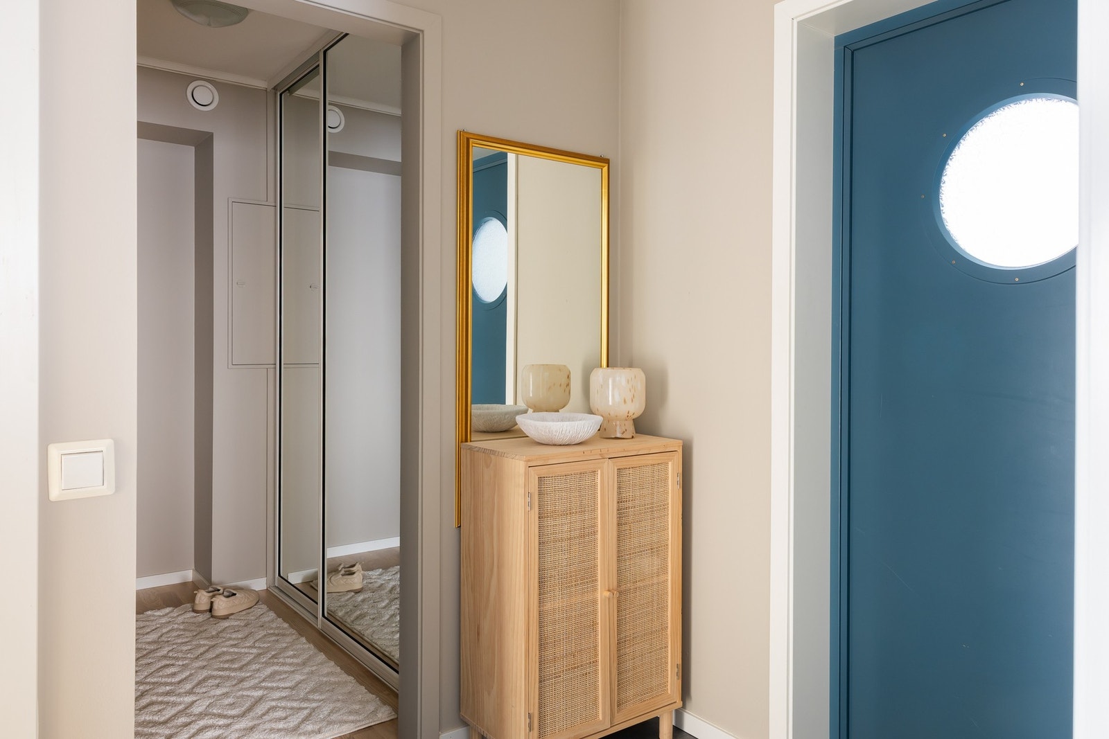 Praktisk entré med egen garderobeavdeling med skyvedørsgarderobe med speildører. Galleribilde