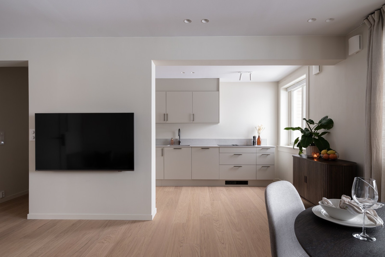 Boligens kjøkken er i en åpen løsning mot stuen, men likevel tilbaketrukket i hjørnet av rommet som gir fine soneinndelinger. Galleribilde