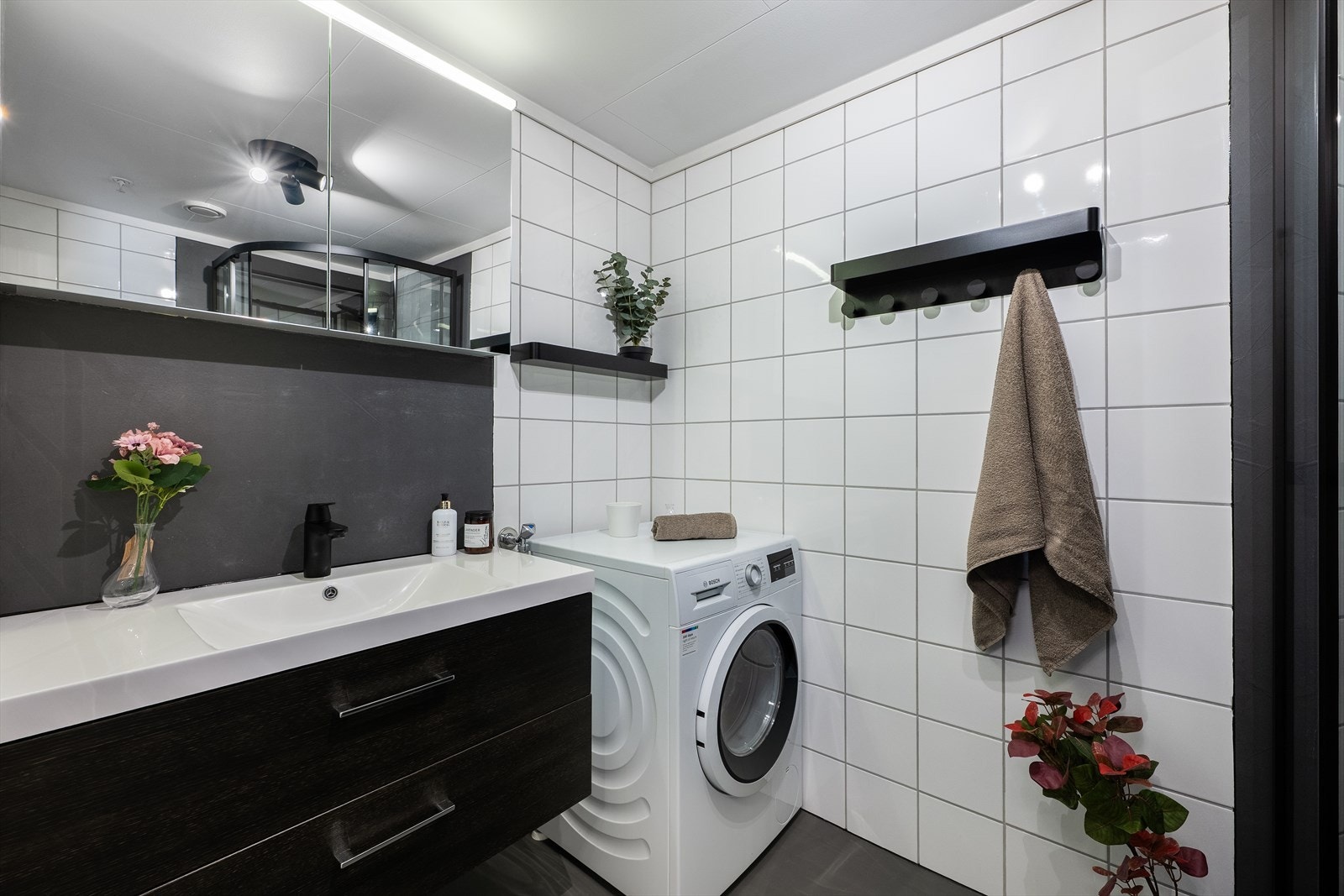 Baderomsinnredning med heldekkende servant og speilskap gir praktisk oppbevaring. Opplegg til vaskemaskin. Galleribilde