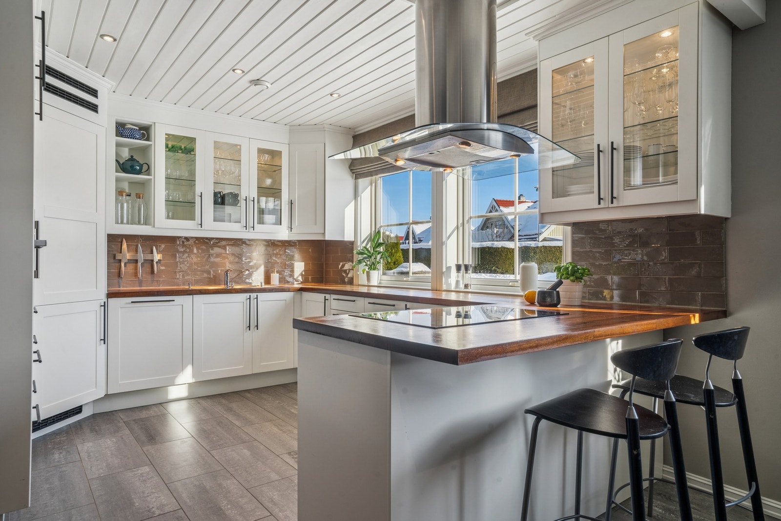 Kjøkkenet har innredning med profilerte fronter og skuffer, kombinert med heltre benkeplate Galleribilde