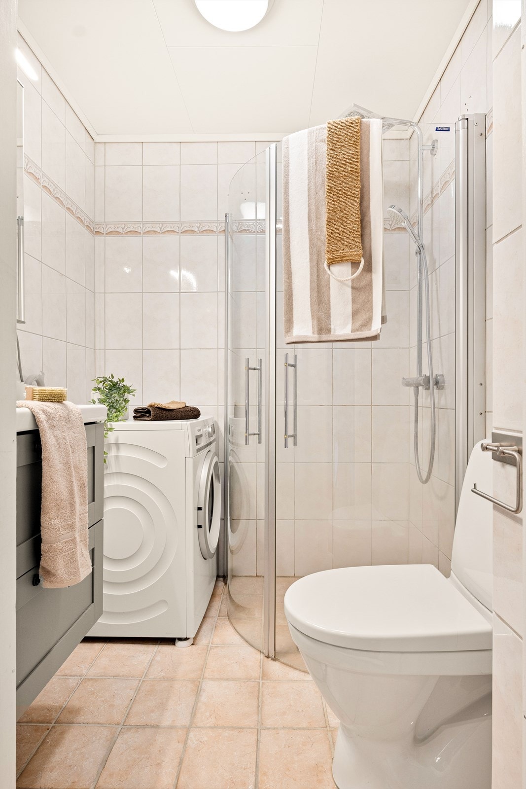 Badet har fliser på gulv og vegger og elektriske varmekabler, samt mekanisk avtrekk. Galleribilde