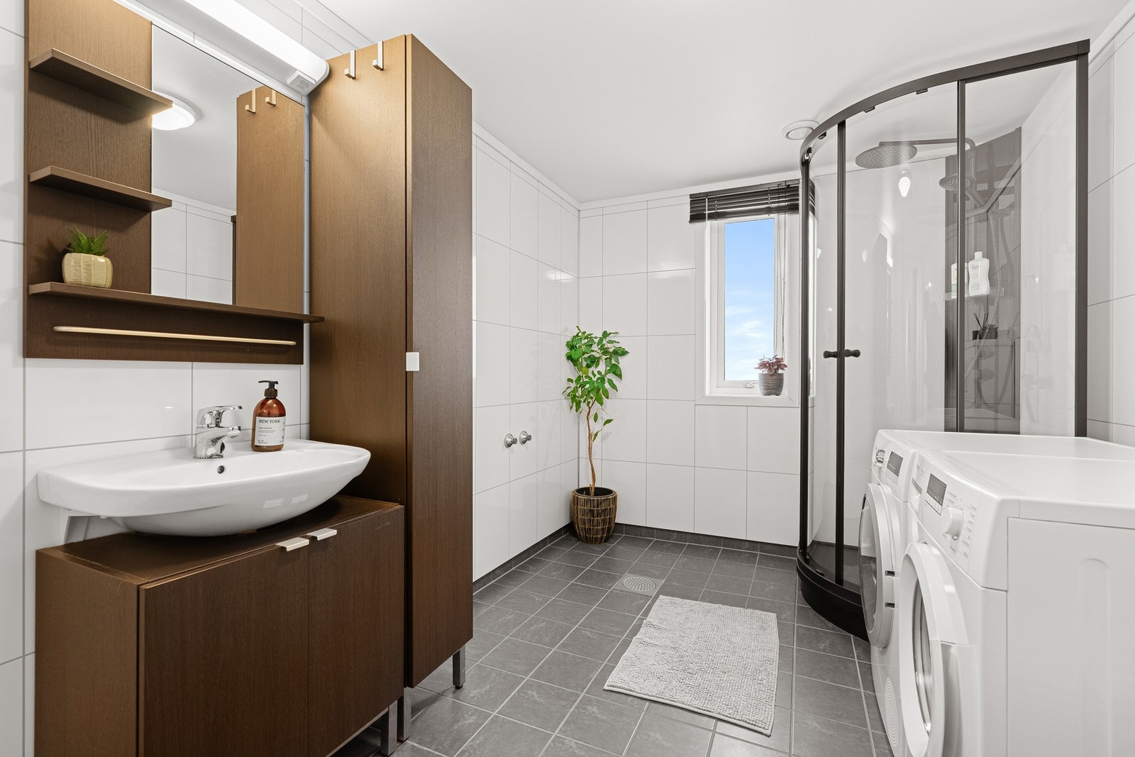 Bad med nyere dusjkabinett og opplegg til vaskemaskin og tørketrommel Galleribilde