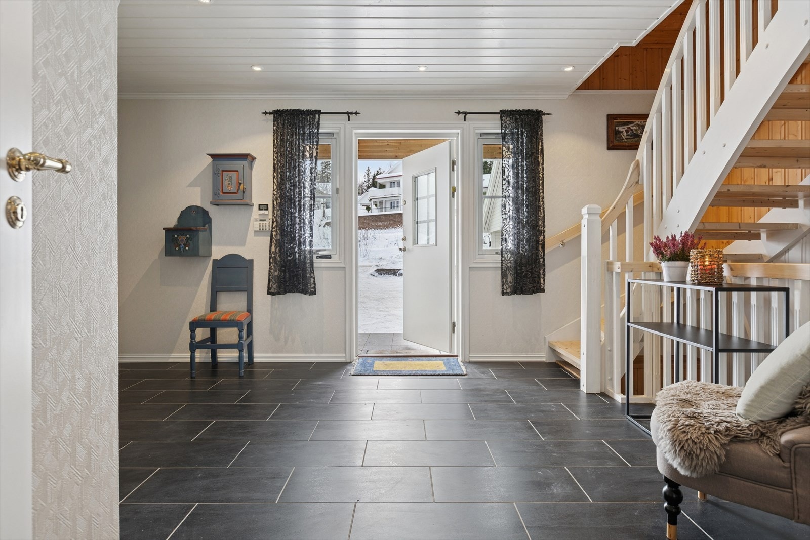 Innbydende hall med fliser på gulvet. Ved inngangspartiet ute er det varmekabler. Galleribilde