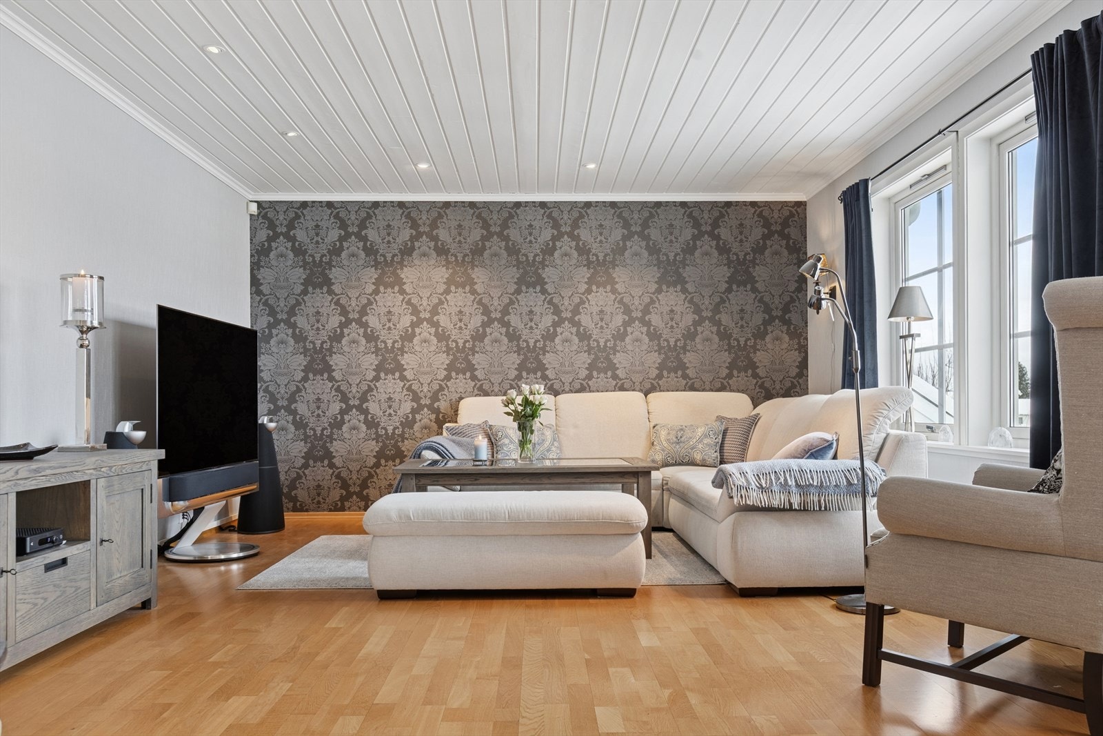 Rommet har parkett på gulvet og en kombinasjon av tapetserte veggflater. Galleribilde